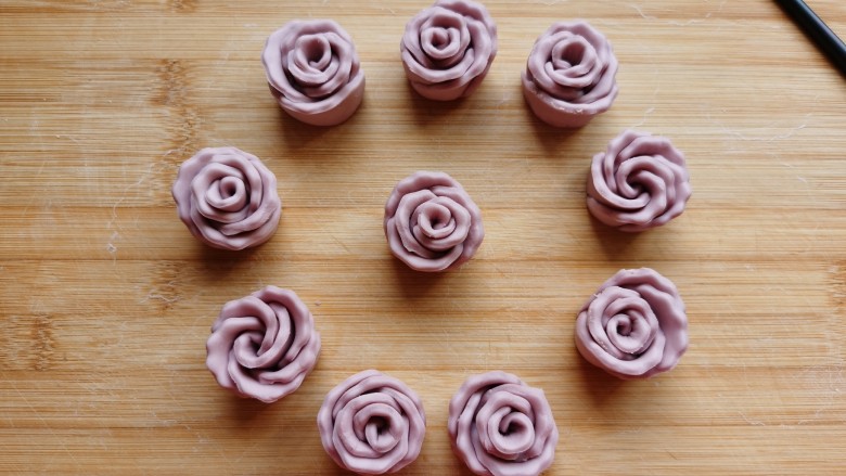 紫薯玫瑰花馒头,双手将玫瑰花底部四周往里收压一下，防止醒发后散开，漂亮的紫薯玫瑰花🌹🌹馒头就做好了。