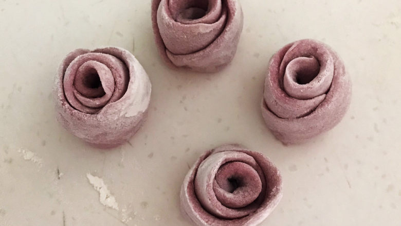 紫薯玫瑰花馒头,然后切从中间切成2段，玫瑰花馒头生坯就做好了