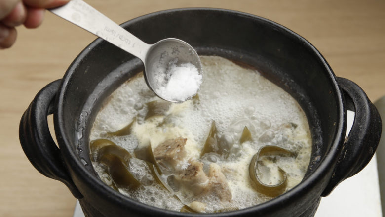 山药海带排骨汤,煲好的汤中撒入适量盐调味。