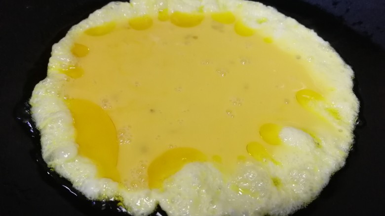 老黄瓜炒鸡蛋,油热倒入打散的蛋液。