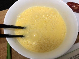 腊肠蒸蛋➕腊肠豆腐蒸蛋,鸡蛋打入碗中，筷子搅散成均匀蛋液