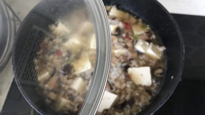 香菇肉末豆腐,让豆腐完全浸在汤汁里，盖上锅盖中小火炖10分钟左右；