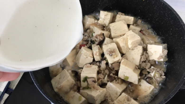 香菇肉末豆腐,豆腐的汤汁收的差不多了，沿着锅边倒入刚才调好的水淀粉；