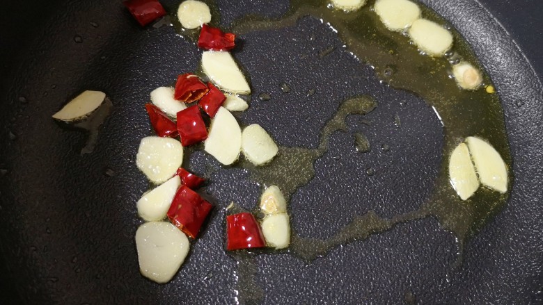 荷兰豆炒香肠,不粘锅内继续倒油烧热，下入蒜片和干红辣椒炒香。