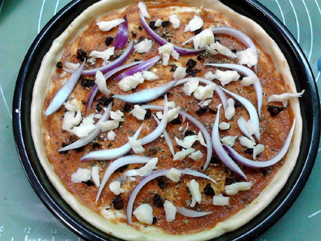 黑椒牛肉披萨,撒少许奶酪和洋葱丝。
