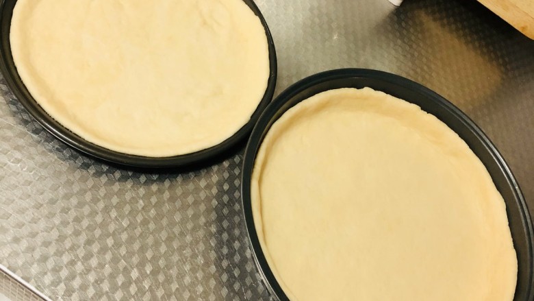 芝士榴莲披萨,发酵好的面团在面板上排气，擀成圆形放入披萨盘中
