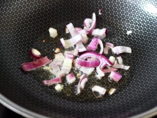 懒人版快手黄瓜火腿意面,锅中倒入橄榄油烧热，先炒香洋葱碎。