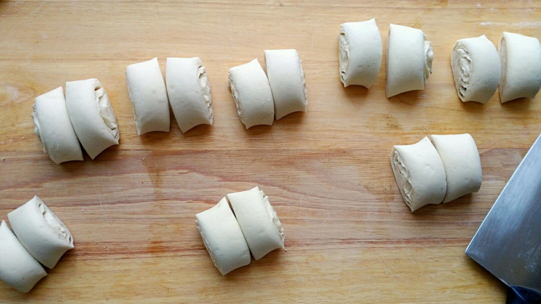 椒盐小花卷,从长的一边开始卷起来，切掉两头，用快刀等分成8快，每一块再从中间切开。