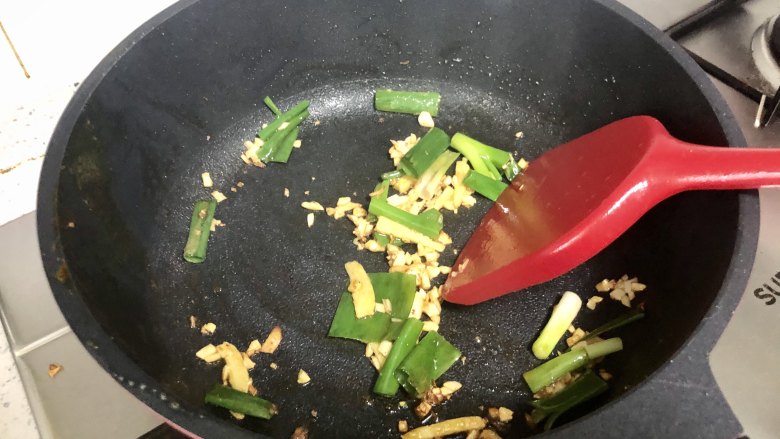 好吃到吮指的油焖大虾,将煎好的虾盛出来备用。锅内留底油，放入姜片，葱丝，蒜末爆香。