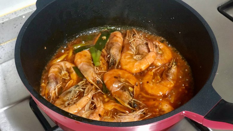 好吃到吮指的油焖大虾,加入一小碗水，水沸后放入煎好的大虾，炒匀。