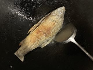 蒜香煎鱼,鱼尾煎好把鱼翻身，同样的方法煎另一面。