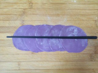紫薯玫瑰花馒头,擀成片，五张面片排列好，用筷子在中间压一下。