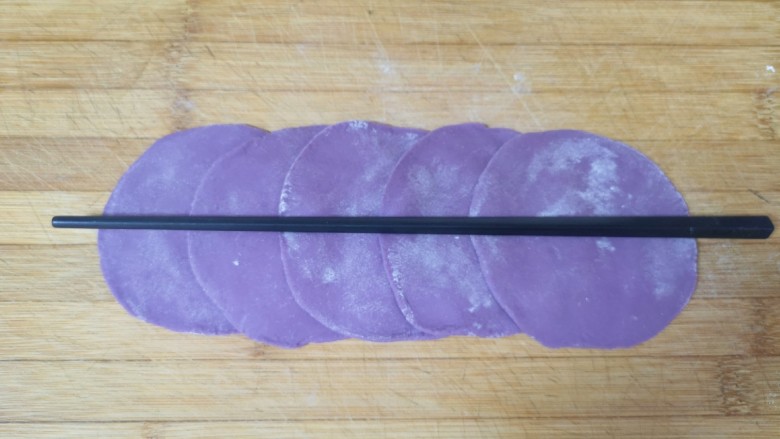 紫薯玫瑰花馒头,擀成片，五张面片排列好，用筷子在中间压一下。
