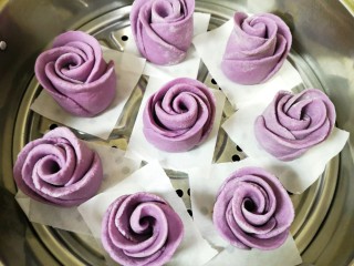 紫薯玫瑰花馒头,蒸锅内放水，篦子上铺上油纸，放上做好的紫薯玫瑰花馒头生胚，盖上锅盖二次发酵10分钟左右，凉水上锅，上汽后大火蒸12分钟关火，焖5分钟左右出锅。