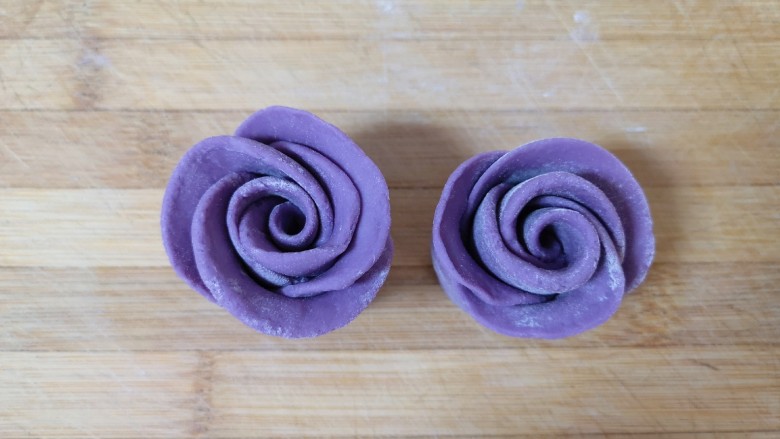 紫薯玫瑰花馒头,切面朝下，整理一下玫瑰花的花瓣，漂亮的紫薯玫瑰花馒头就做好了，依次做好剩下的面团。