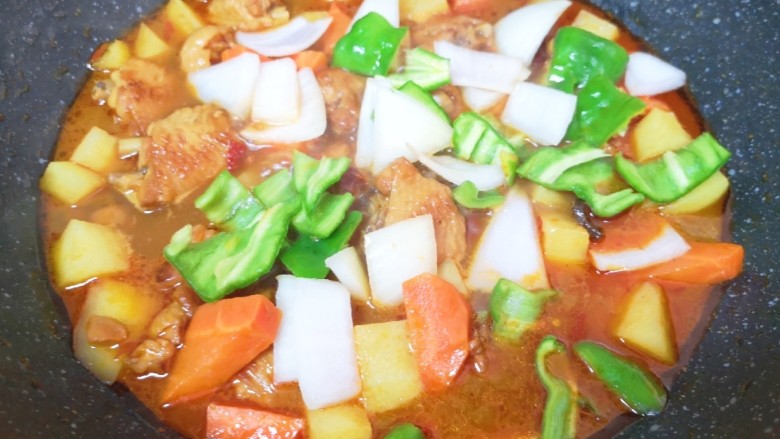 鸡腿炖土豆,下入青椒和洋葱翻炒1-2分钟。
