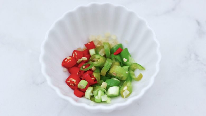 白灼鲍鱼,把切好的小米辣和绿尖椒，姜末和小葱放入碗里。