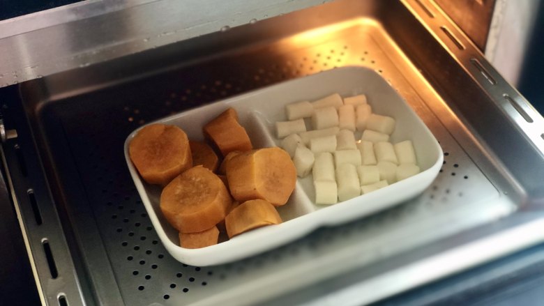 酸奶麦片红薯山药糕，颜值高又饱腹,把红薯和山药块放入蒸箱，蒸20分钟，把红薯和山药蒸至软烂。