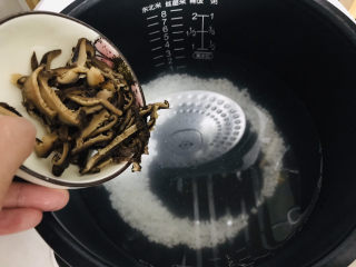 香菇滑鸡粥,切好的香菇片倒入电饭锅内胆，跟大米一起预约熬成明早要用的粥底；