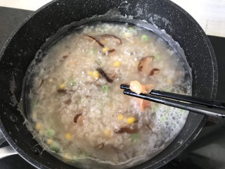 香菇滑鸡粥,一筷子一筷子地加入到粥底中搅匀，大概40秒鸡肉就变色熟透；