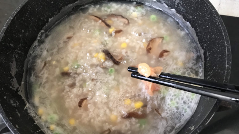香菇滑鸡粥,一筷子一筷子地加入到粥底中搅匀，大概40秒鸡肉就变色熟透；
