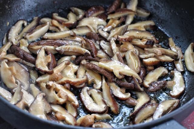 香菇炒肉片,锅中再添适量食用油烧热后，放入香菇炒出香味。