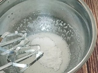 蛋白糖,等打到出现纹路后加入剩余的糖粉，继续打发。