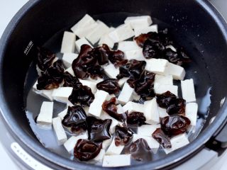 海鲜木耳豆腐羹,锅中倒入适量的清水，放入焯过的豆腐和木耳。
