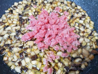 香菇牛肉酱,杏鲍菇和香菇炸至体积明显变小的时候下入牛肉粒翻炒均匀。
