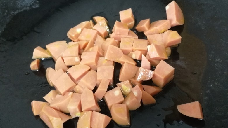 豌豆糯米饭,放入火腿肠，小火炒匀炒香。