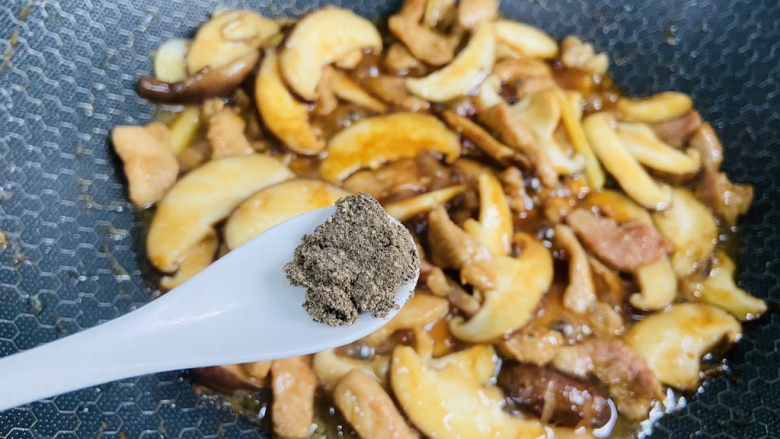 香菇炒肉片,加入适量的黑胡椒粉翻炒均匀