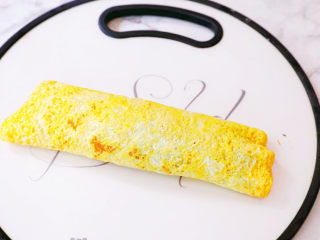 芋泥肉松鸡蛋卷,最后将蛋皮小心的卷起来，再用刀对半切开