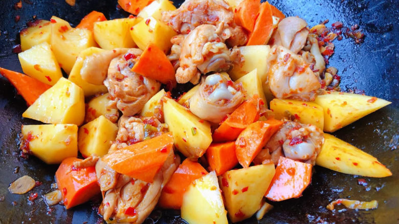 鸡腿炖土豆,放入胡萝卜块断生使每个食材均匀的裹上酱料
