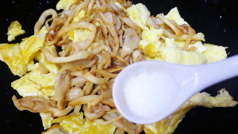 平菇炒鸡蛋,放入炒好的鸡蛋，洒半小勺盐中小火翻炒均匀。