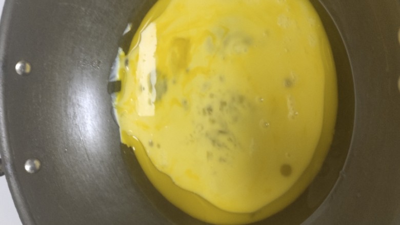 平菇炒鸡蛋,鸡蛋液倒入锅中