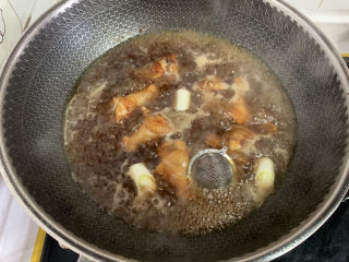 鸡翅根炖土豆南瓜,加入葱段、姜片和大料、花椒、辣椒。