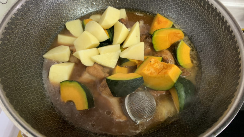 鸡翅根炖土豆南瓜,15分钟后加入切好的南瓜和土豆块。
