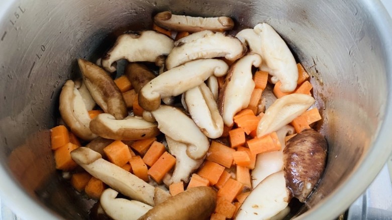 香菇滑鸡粥,锅中放少许油，把香菇，胡萝卜丁放进去，爆香。