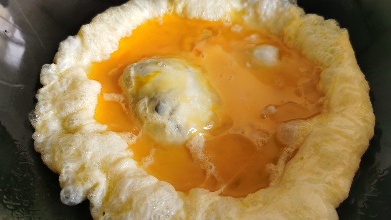 平菇炒鸡蛋,炒锅烧热放油，倒入蛋液翻炒。
