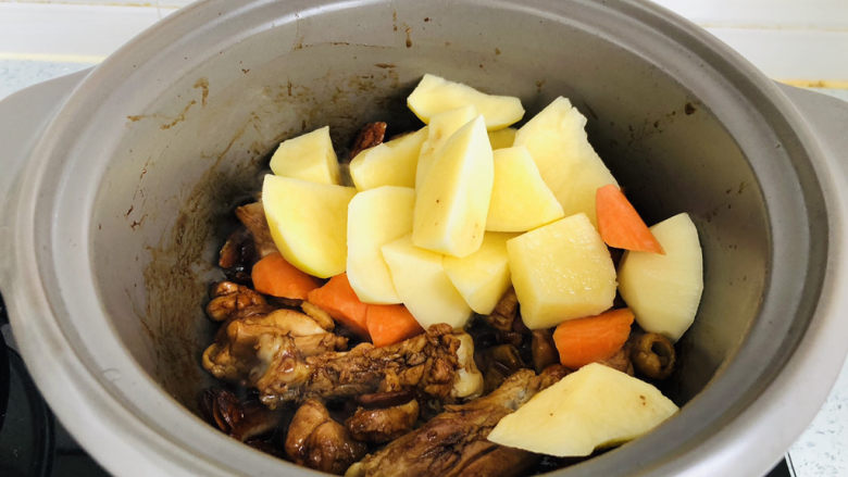 鸡腿炖土豆,放入土豆、胡萝卜翻炒均匀。