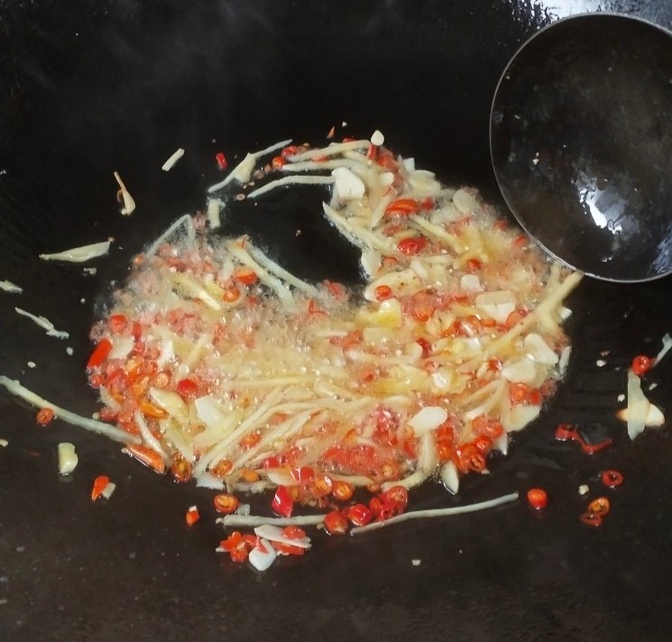 泡椒猪肝,锅中留底油，然后把泡姜，大蒜，小米辣下锅炒香。