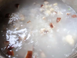 香菇滑鸡粥,大米粥煮至六成熟放入鸡腿肉和香菇改中火煮起来