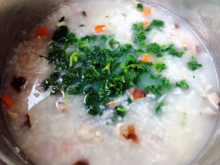 香菇滑鸡粥,最后放入芹菜叶同时放入盐和味精调味均匀即可出锅享用