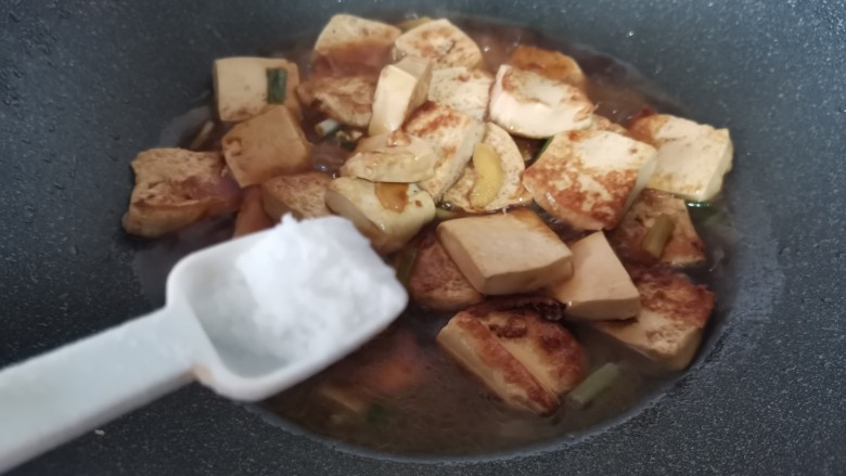 青椒炒豆腐,豆腐里放入一勺盐。