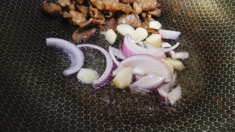 香菇炒肉片,将炒好的肉片推在锅边，用锅中底油爆香蒜片和洋葱丝