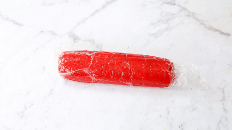 西瓜饼干,将红丝绒面团放入保鲜膜，搓成圆柱状，再放入冰箱冷冻30分钟定型
