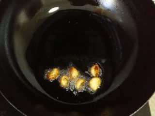 重庆鸡公煲（简易版 ）,热锅凉油，下入蒜瓣，小火煸黄、煸出蒜香