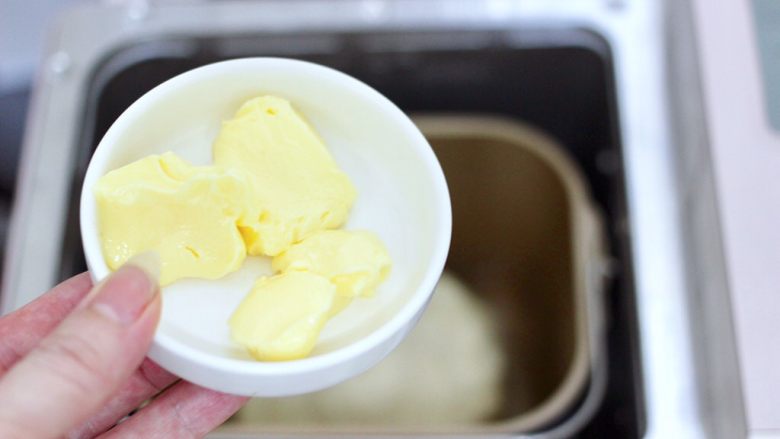 牛奶杏仁小餐包,揉成面团后加入软化的黄油，继续和面10分钟。