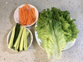 快手午餐肉蔬菜卷饼,生菜洗净，黄瓜洗净切成条，胡萝卜洗净去皮切成条。