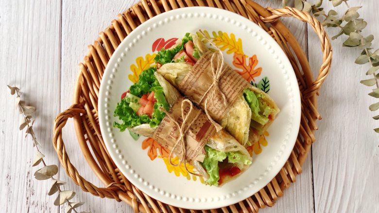 快手午餐肉蔬菜卷饼,把印度飞饼和所有食材一起卷起来，外面裹上硅油纸，中间用麻绳系紧即可。